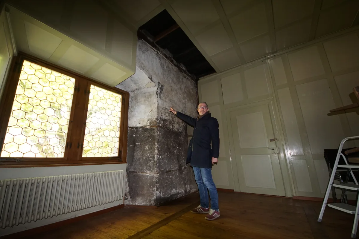 Marco Zanoli steht in einem Zimmer des Ritterhauses und zeigt auf eine Wand. 